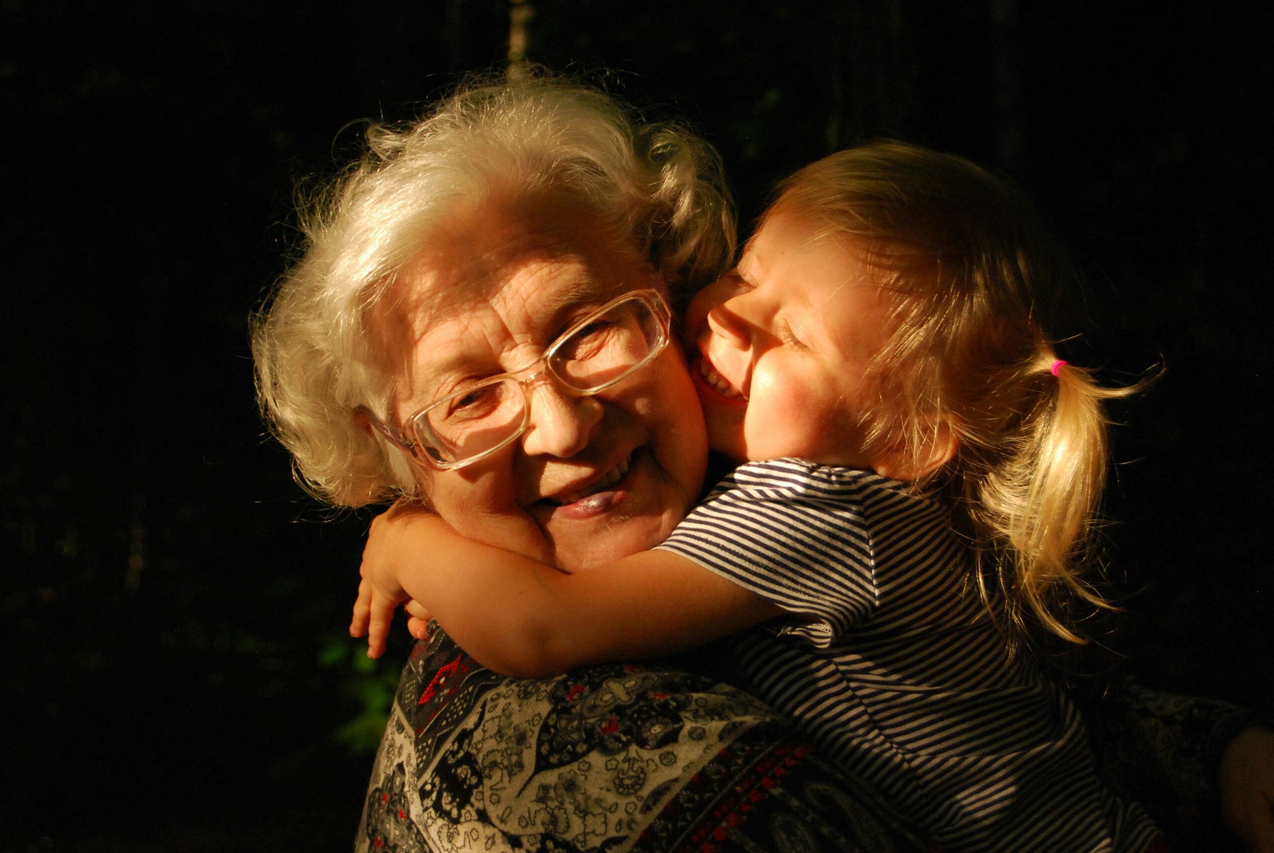 Smiling grandmother hugging joyful granddaughter, highlighting the emotional value of secure retirement and legacy planning.